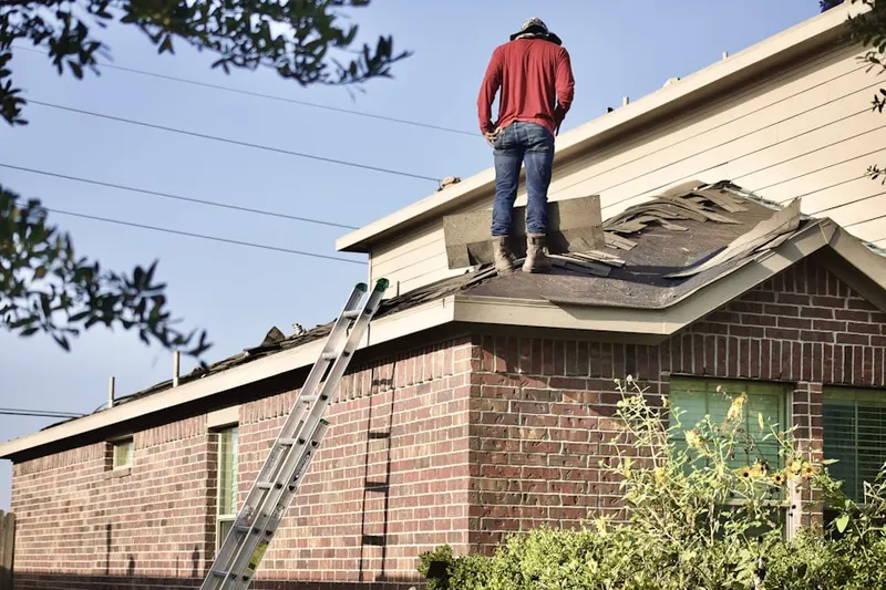 Professional roofer working on a residential roof in Brook Hollow